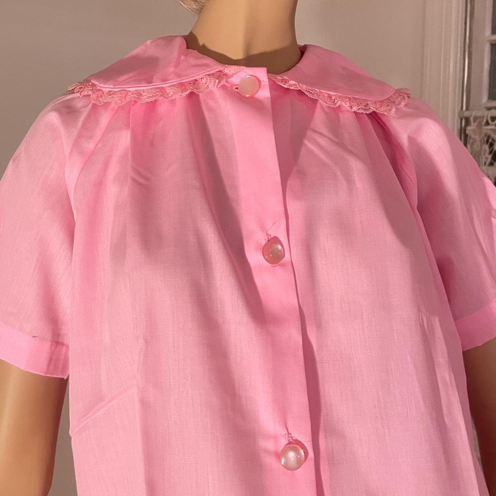 Pink vintage housecoat with floral embroidery and lace detail on pockets. Small